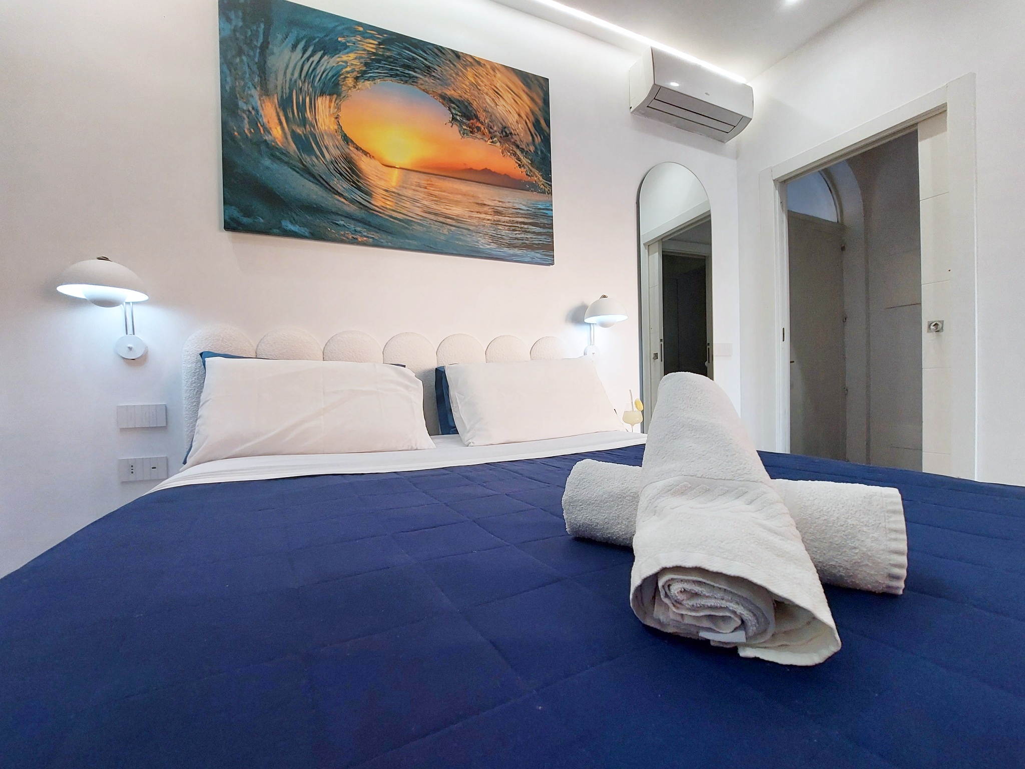 Bed with towels and sunset artwork